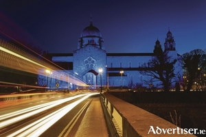 Galway Cathedral lit up blue at night and car lights trails