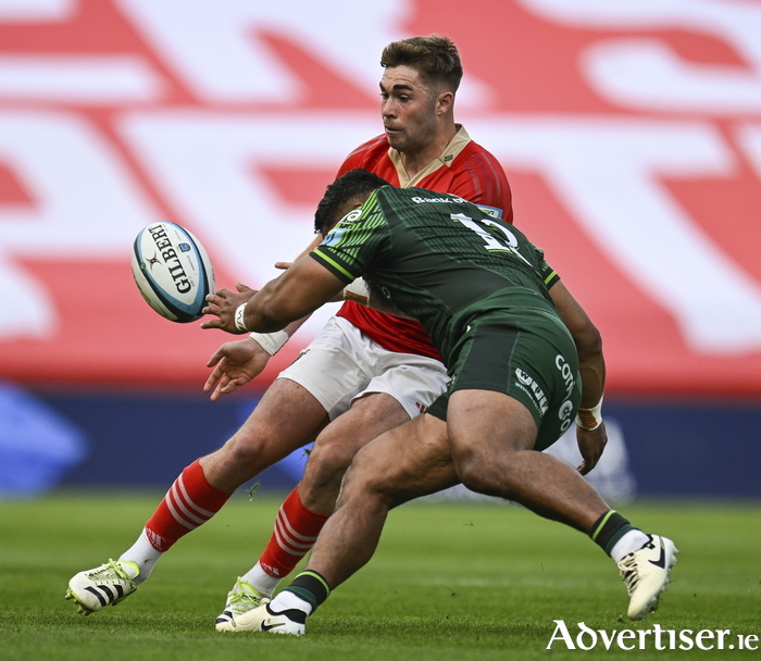 Jack Crowley of Munster is tackled by Bundee Aki of Connacht during the United Rugby Championship match between Munster and Connacht at Thomond Park.