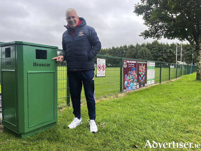 Councillor Shane Forde with a new bin he arranged at St James' GAA in Mervue