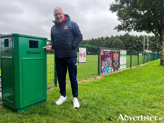 Councillor Shane Forde with a new bin he arranged at St James' GAA in Mervue