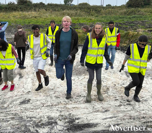 Students from the University of Galway and other volunteers are pictured jumping up and down to compress the soil for water retention at the base of the new pond in Terryland Forest Park last Saturday.